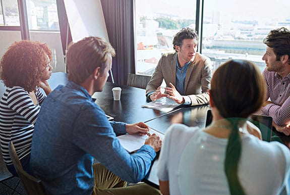 Staffing Firm Meeting Room with five people discussing hiring staff